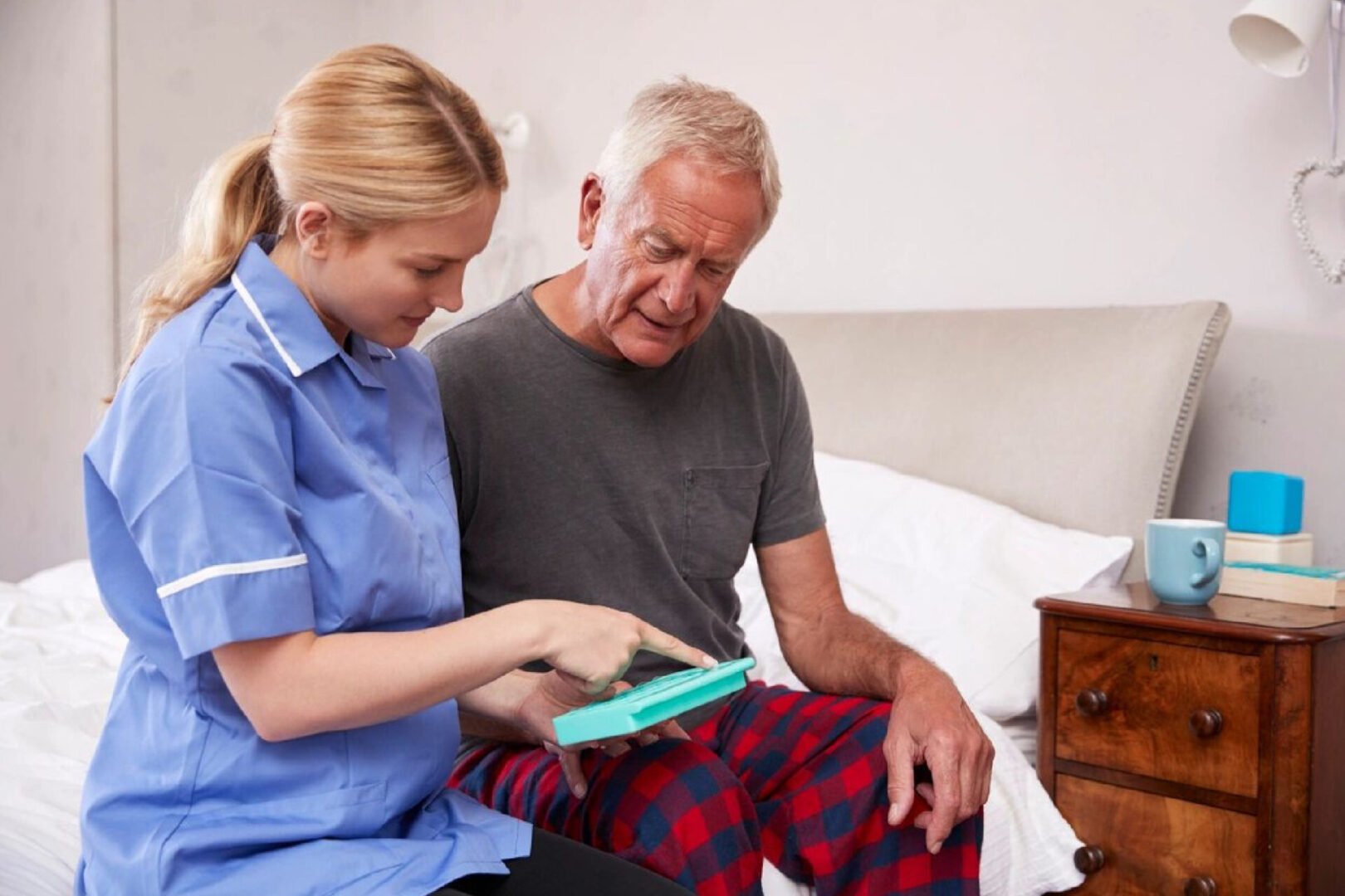 A nurse is helping an older man with his medical equipment.